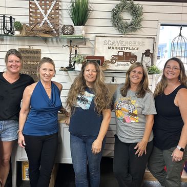Scavengers team members standing behind the sales counter.