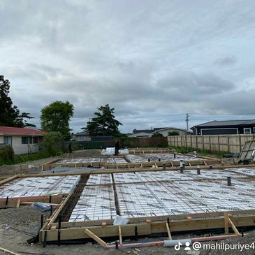 Foundation work underway for a building on a cloudy day.