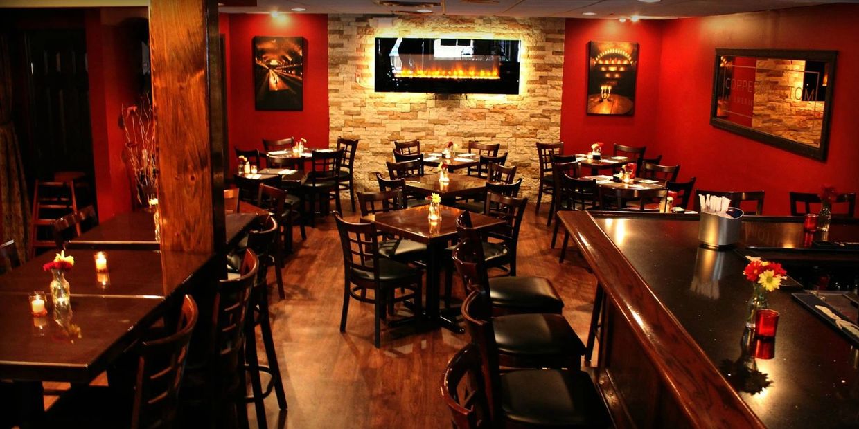 Fireplace pub room with bar and TVs and hightop seating.