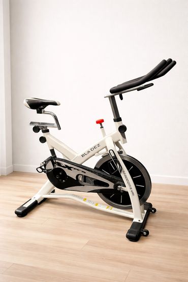 White indoor exercise bike with black seat and handlebars.