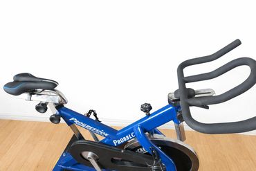 Blue stationary exercise bike with padded seat and handlebars.