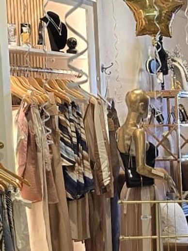 Chic boutique with gold star balloons and customers inside.