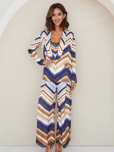 Woman in a colorful chevron-patterned suit smiling.