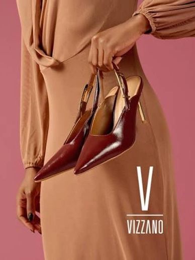 Woman holding elegant brown high-heeled shoes.