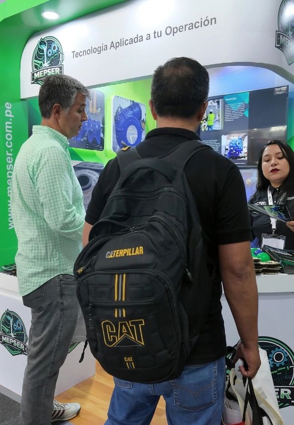 People interacting at a technology-focused exhibition booth with company branding.
