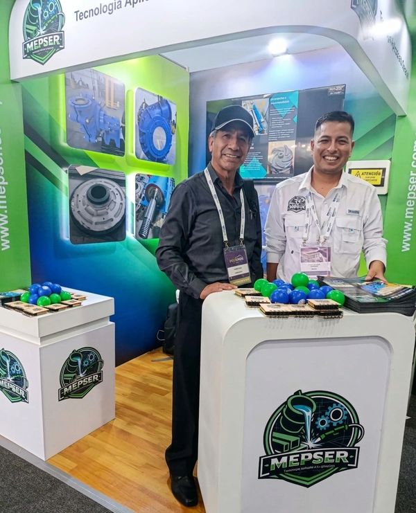Two men standing at a Mepser technology booth with promotional materials.
