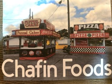 Two food stands selling funnel cakes and pizza.