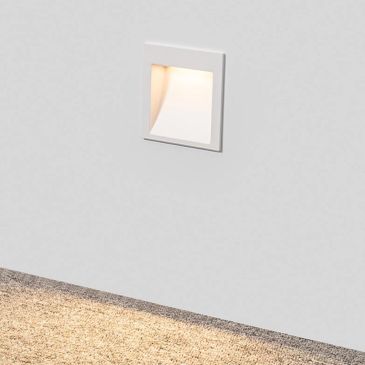 Recessed wall light illuminating a textured floor.
