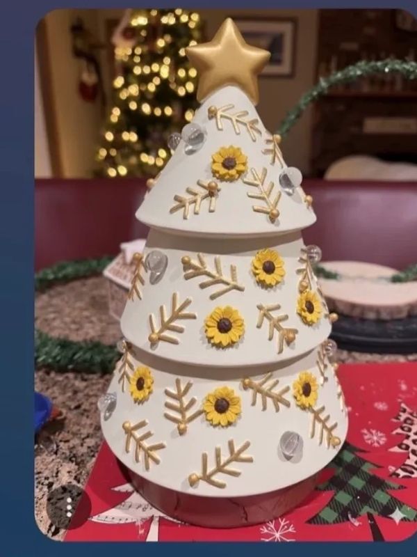 Decorative white Christmas tree with gold and yellow flower accents.