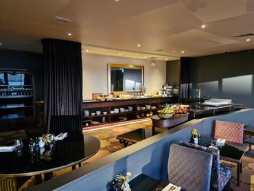 Elegant dining area with buffet and fresh fruit in soft lighting.