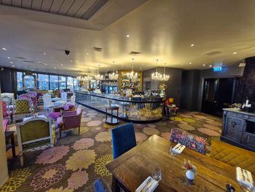 Cozy bar area with vintage chairs and floral carpet.