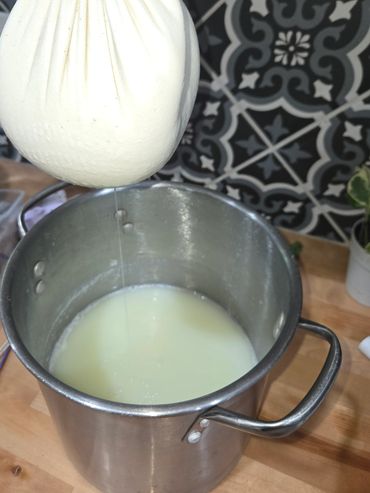 Picture of us taking the ricotta curd out of the whey.