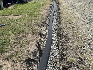 Drainage pipe being installed beside a house.