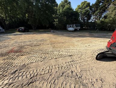 Cleared land with vehicle and trailer near trees.
