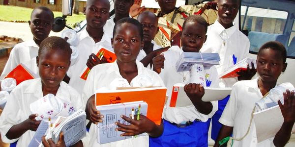 Kinderen in schooluniform met boeken en schriften.