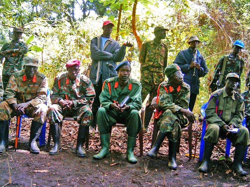 Een groep soldaten in camouflage en uniformen in een bos.