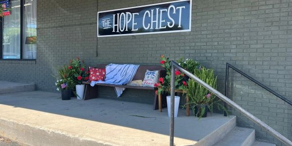 Bench with cushions and plants outside The Hope Chest store.