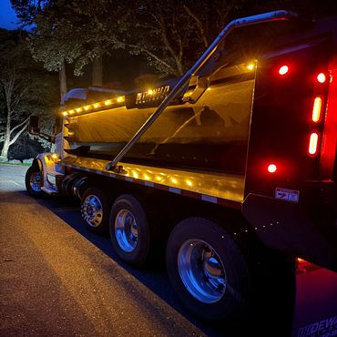dump truck in dark with lights on