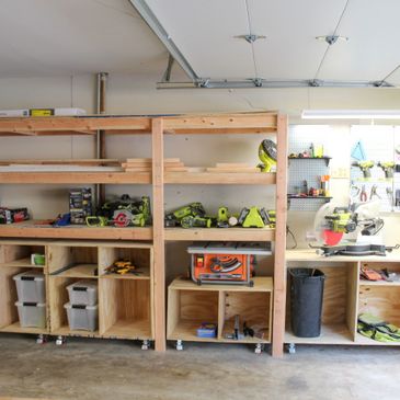 Organized garage workspace with wooden shelves and power tools.
