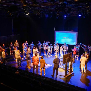 Group activity on a stage with projected screen.