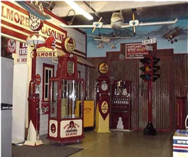 Vintage gas station display with old fuel pumps and signage indoors.
