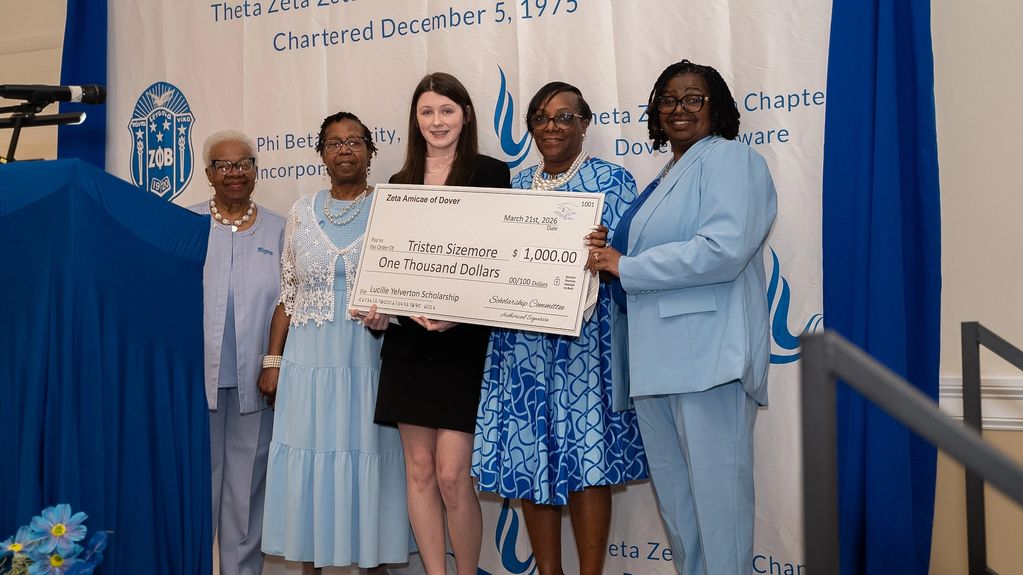 Five women hold a large $1,000 scholarship check at a Zeta Phi Beta event.