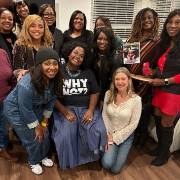 Group of women smiling and posing indoors.