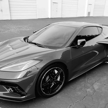 A sleek sports car parked in a lot with reflective surfaces.