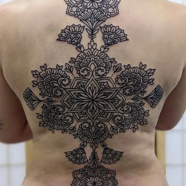 Intricate black floral mandala tattoo covering the entire back.