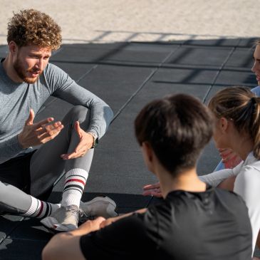 Group fitness instructor explaining workout techniques to participants.