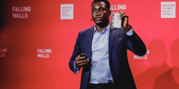 Man in suit speaking at Falling Walls event.