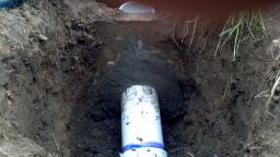 Septic tank outlet properly sealed with hydraulic cement.