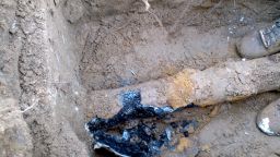 Old cast iron pipe plugged with sludge.