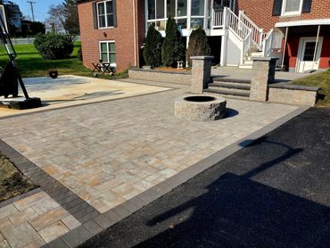 Backyard outdoor living. Paver patio, walls, stairs, columns, fire pit