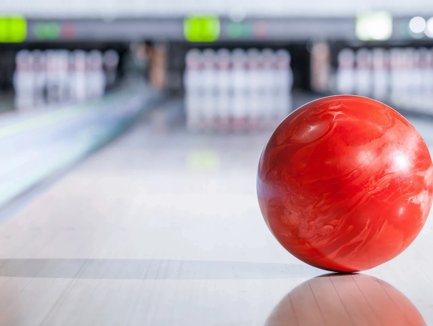 bowling ball sitting behind pins