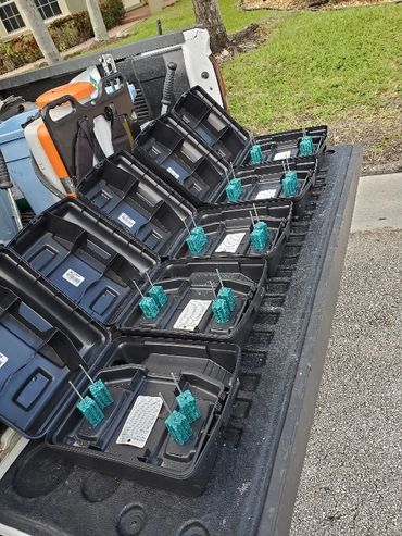 Multiple black bait stations with blue rodent bait blocks arranged on a truck bed.