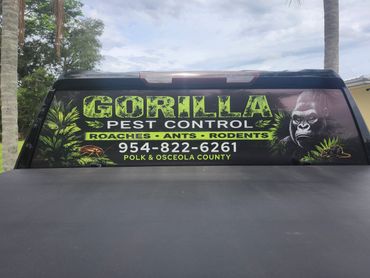 Back window advertisement for Gorilla Pest Control with contact info and pest types.