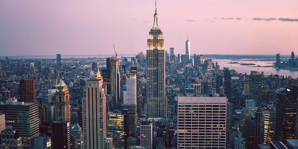 A panoramic view of New York City skyline with the Empire State Building at dusk.