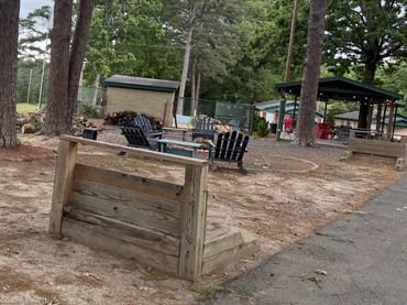 Outdoor seating area with trees and cloudy sky.
