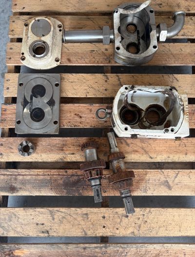 Disassembled mechanical parts on a wooden pallet.