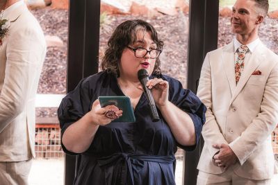 Woman speaking into a microphone at a formal event.