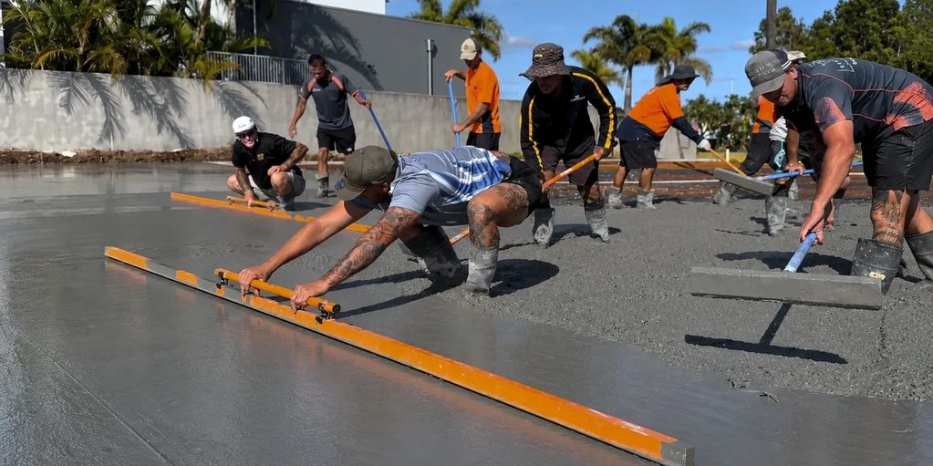 A group of concreters screeding and laying a slab