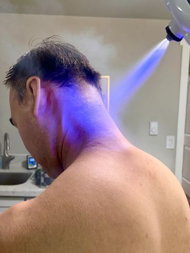 Man receiving light therapy on his neck.