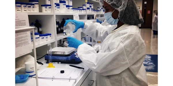 Scientist in protective gear working with chemicals in a lab. Emma Banks. Emmaly Lugo.