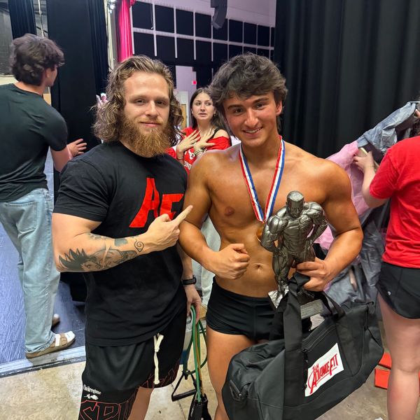 Two men celebrating a fitness competition win.