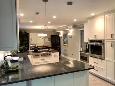 Updated kitchen with pendant lights and dark countertops as contrast to light cabinets