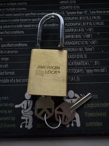Unlocked American Lock padlock with two keys on a black background.