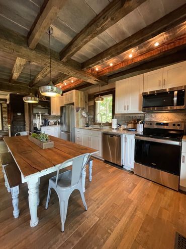 Fully equipped eat-in kitchen with modern stainless steel appliances.