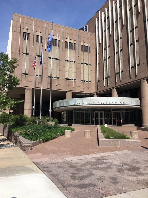 Entrance of Hennepin County Public Safety Facility with greenery and pillars.