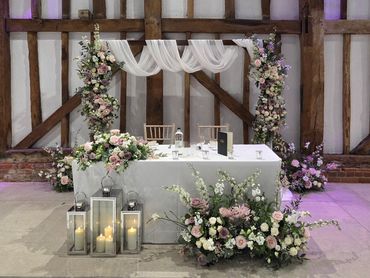 Wedding sweetheart styling with floral backdrop and lanterns at The Great Barn at Headstone Manor